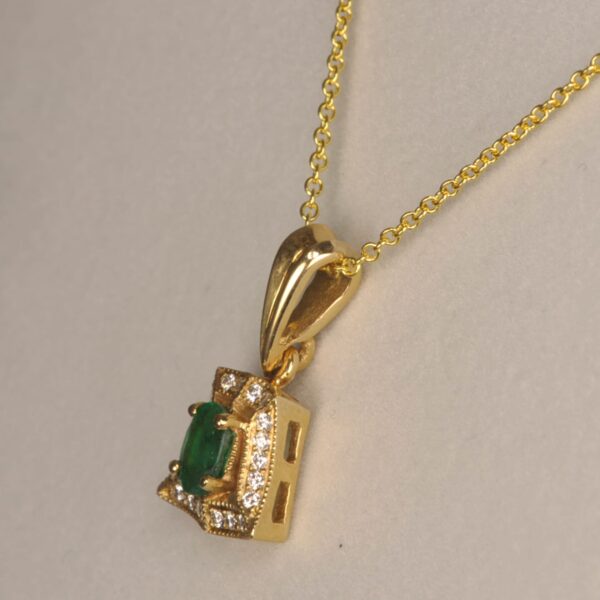 Fine emerald and diamond pendant set in 14K yellow gold