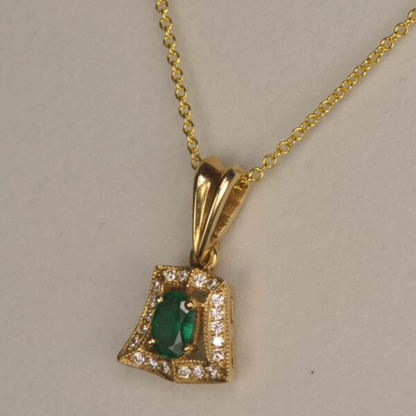 Fine emerald and diamond pendant set in 14K yellow gold